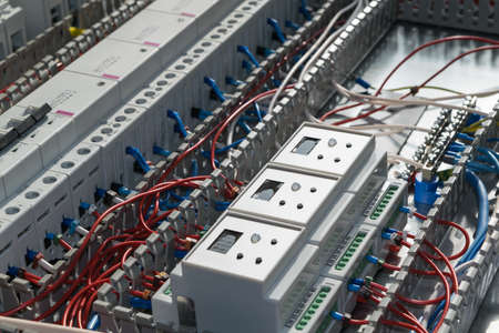 A series of modular magnetic contactors and a range of power circuit breakers. Between the rows of contactors and switches and devices, perforated cable channels. They laid the electrical wire.の写真素材