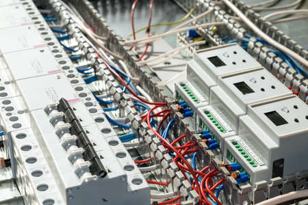 A series of modular magnetic contactors and a range of power circuit breakers. Between the rows of contactors and switches and devices, perforated cable channels. They laid the electrical wire.の写真素材