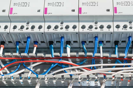 A number of modular contactors, cable channel and wire. Wire laid in the cable channel and connected to the modular contactors in electrical Cabinet. The wires from the terminals and marking.の写真素材
