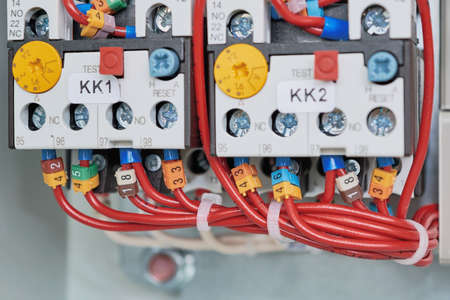 Two power contactor with adjustable and connected to it by wires. Wire bound with plastic collars in a bun. Left-hand contactor in the field. Starters for starting the engine.の写真素材