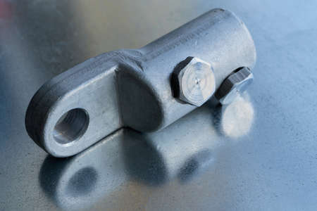 Metallic bolt cable lug with bolt clamps rests on the circuit Board. The tip of the large cross-section for connection of electric cables in electrical installations or cabinets. Electrical industry.の写真素材