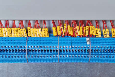 Lot electrical feed-through terminals, arranged in a row. To them are attached the electric wires...