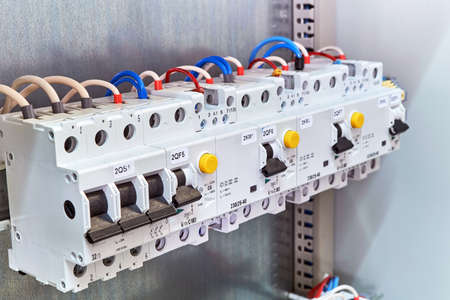A range of different modular electrical devices in an electrical Cabinet. Circuit breaker, protection device of the differential current, modular contactor is wired according to the diagram.の写真素材