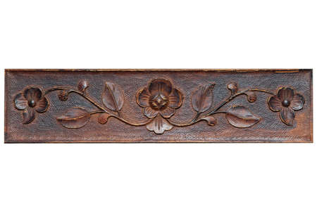 Beautiful pattern in the form of flowers and leaves on a wooden plank. Carving. Element of decoration of wooden furniture. Old style. Rustic decoration. Weathered, ragged. Isolate on white background.の写真素材