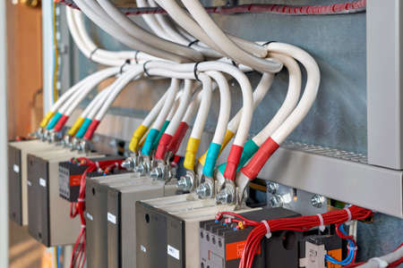 A large bundle of electrical cables or wires connected to contactors. High-power magnetic starters. Connection using a bolted connection. Large electrical Cabinet. Modern and reliable equipment.の写真素材