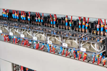 A range of electrical intermediate relays in an electrical Cabinet. The wires are connected to the relay by means of tips and marked according to the project. Production automation.の写真素材