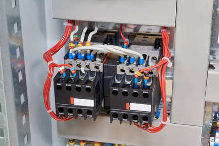 Two magnetic contactor connected in reverse starting Assembly. Wires are connected to contactors and additional contacts according to the scheme or project. Modern production of electrical cabinets.の写真素材