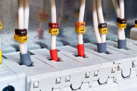 The electrical wires are connected to circuit breakers or fuse holders. The cables have insulated terminals. Reliable and safe connection of electrical equipment. Modern technology and protection.の写真素材