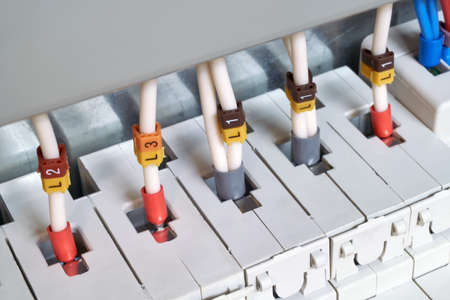The electrical wires are connected to circuit breakers or fuse holders. The cables have insulated terminals. Reliable and safe connection of electrical equipment. Modern technology and protection.の写真素材