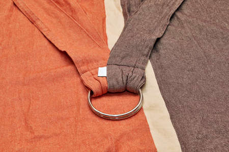 Baby sling newborn of durable fabric and two metal rings. Convenient device for carrying and feeding a small child. Psychological comfort for the baby.の写真素材