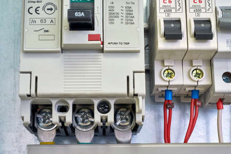 Large industrial circuit breaker and modular electrical circuit breakers. Electrical wires or cables are connected to the switches. A number of electrical equipment in an electrical Cabinet.の写真素材