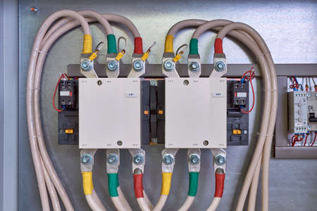 Electrical cables and wires are connected to magnetic starters or contactors. Additional contacts are installed on the sides. Right voltage relay and circuit breaker. Cables are bent to connect to.の写真素材