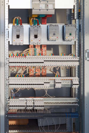 Large electrical switch Cabinet with circuit breakers and terminals. Several powerful and a lot of switches series modular switches. Cables and wires are connected to circuit breakers and buses.の写真素材
