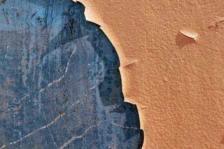 The surface of the metal wall with exfoliated old paint. Paint orange swollen and opal from weather and time. The painted surface cracked, split and crumbled. Texture, backdrop.の写真素材