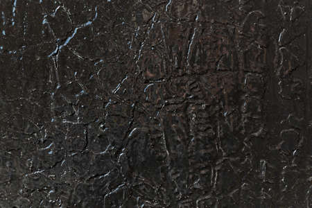 The surface of the wall is painted with black glossy oil paint over the old cracked and exfoliated. Surface of the dark paint is smoothed and shiny. Cracks in the form of lines of different shapes.の写真素材