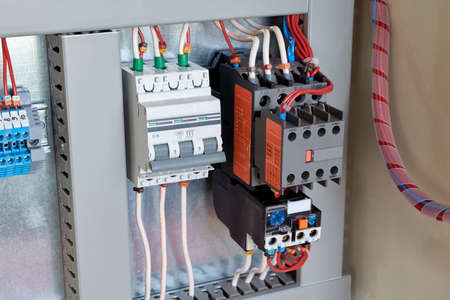 Circuit breaker, contactor or starter with additional contacts and thermal relay in electrical Cabinet. Electric control Cabinet for pumps or motors. The wires are connected to electrical equipment.の写真素材