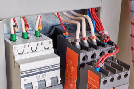 The wires are connected to electrical equipment. Circuit breaker, contactor or starter with additional contacts in electrical Cabinet. Electric control Cabinet for pumps or motors.の写真素材