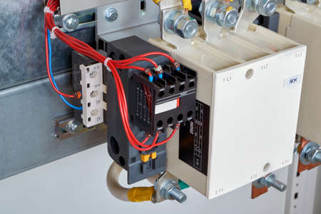 The electrical wires are connected to the side additional contacts of a powerful contactor or magnetic starter in the electrical Cabinet. Automation and uninterrupted power supply.の写真素材