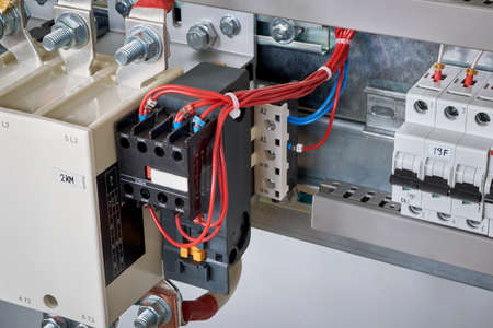 The electrical wires are connected to the side additional contacts of a powerful contactor or magnetic starter in the electrical Cabinet. Automation, uninterrupted power supply. Right circuit breaker.の写真素材