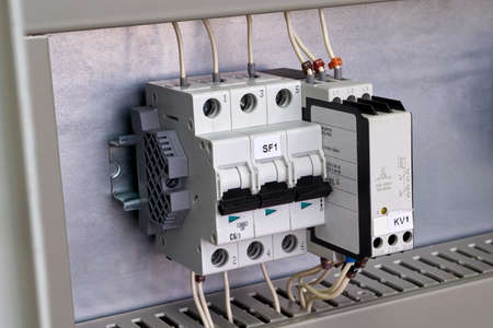 Modular circuit breaker and phase change control relay on the circuit Board in the electrical Cabinet. The devices are connected to the mains by electrical wires. Convenient and modern technology.の写真素材