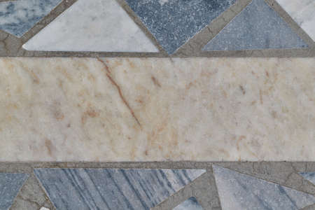 The surface of the floor or wall is made of marble or granite tiles. In the center of the tile rectangular shape. Around the rectangle, the tiles are triangular in shape. The tiles have bands of gray.の写真素材