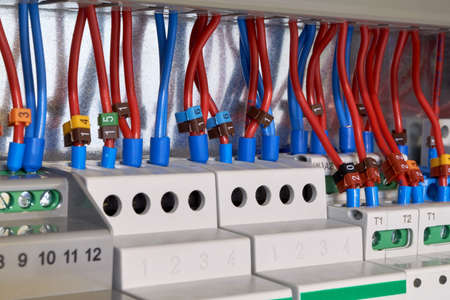 Many electrical wires or cables are connected to magnetic starters and other electrical devices. The electrical equipment is arranged in a row. Modular equipment in the electrical Cabinet.の写真素材