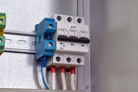 Modular circuit breaker and pass-through terminals in electrical Cabinet. The switch and the terminal are connected to the mains by cables and wires. Manufacture, repair, adjustment, automation.の写真素材