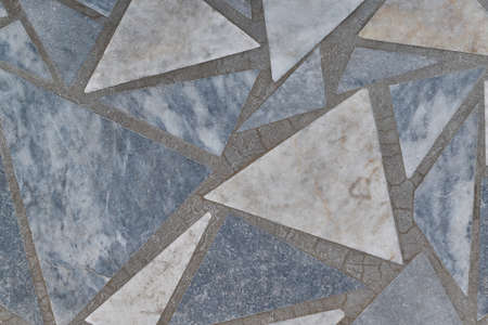 The floor surface is made of granite or marble triangular tiles. Tiles of different sizes are arranged in a chaotic order.の写真素材