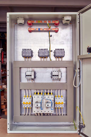 Modern electrical Cabinet for automatic reserve input with contactors, circuit breakers, phase control and voltage control relays. The wires are connected to electrical equipment.の写真素材