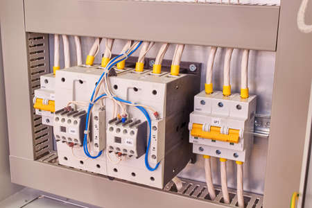 Two power contactors with front additional contacts and two circuit breakers in the electrical Cabinet. Cables and wires are connected to magnetic starters and switches according to the project.の写真素材