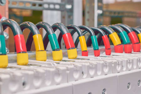 A series of several electrical wires or cables connected to power circuit breakers in an electrical Cabinet. Each wire is marked with a color. Assembly of electrical equipment in production.の写真素材
