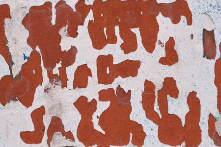 Peeling pink paint on the wall of the building. Paint that has fallen off from the weather effects...