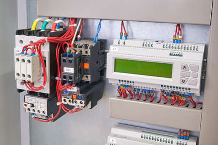 Remote access and control controller with expansion module, two contactors with thermal relays and additional contacts in the electrical Cabinet. Production, installation and maintenance.の写真素材