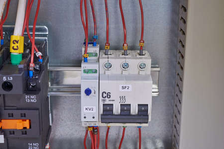 Automatic switch, phase control relay and contactor or magnetic starter with connected wires and...