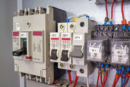 Power circuit breaker, modular circuit breakers and intermediate relays in the electrical Cabinet. Electrical wires are connected to the electrical equipment. Installation, mounting, and maintenance.の写真素材