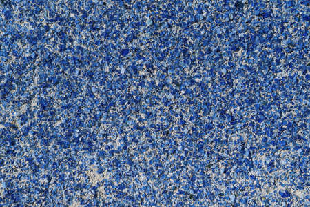 A lot of small blue glass stones on the wall surface are glued with an adhesive compound. Pieces of glass of different shapes. Decoration of the building wall outside. Background, texture.の写真素材