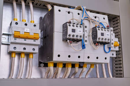 Two powerful power contactors with front additional contacts and two circuit breakers in the electrical Cabinet. Electrical wires are connected to electrical equipment. Maintenance and service.の写真素材