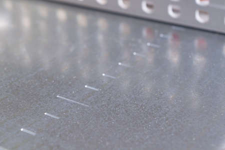 Clean metal panel for mounting electrical equipment and electrical components with markings for easy installation. In the background, a perforated cable channel for laying wires.の写真素材