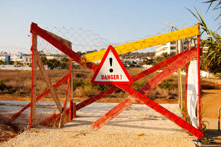 road sign with warning symbol and inscription DANGER