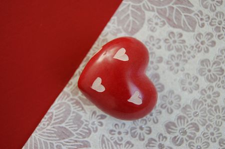 Small wooden heart on a red and white background
