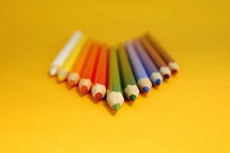 Arrow made of color pencils on a yellow backgroundの写真素材