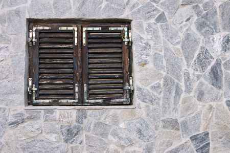 Window with closed dark brown wooden shuttersの写真素材