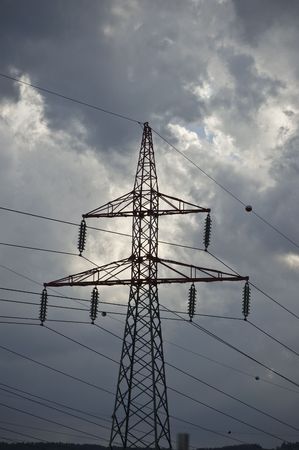 Electricity pylon and the high tension electrical power lines with a stormy sky