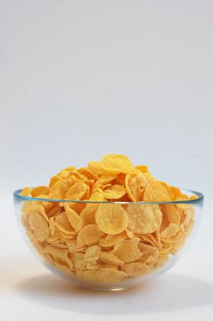 Class bowl with crispy fresh corn flakes on a white background