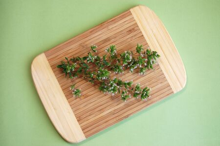 Freshly picked blooming marjoram on a wooden plateの写真素材