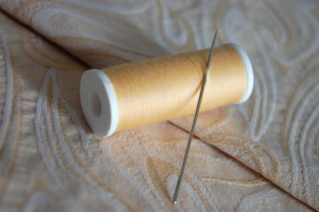 Thread and needle on an embroidered cloth