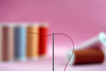 Colorful threads with a threaded sewing needleの写真素材