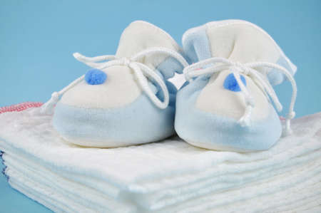 Blue baby sleepers on a pile of cotton diapersの写真素材
