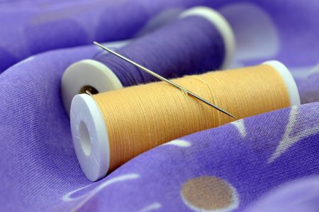 Needle and spools on floral clothの写真素材