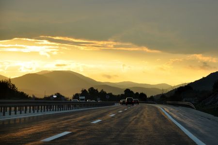 Cars driving on a highway at sunset